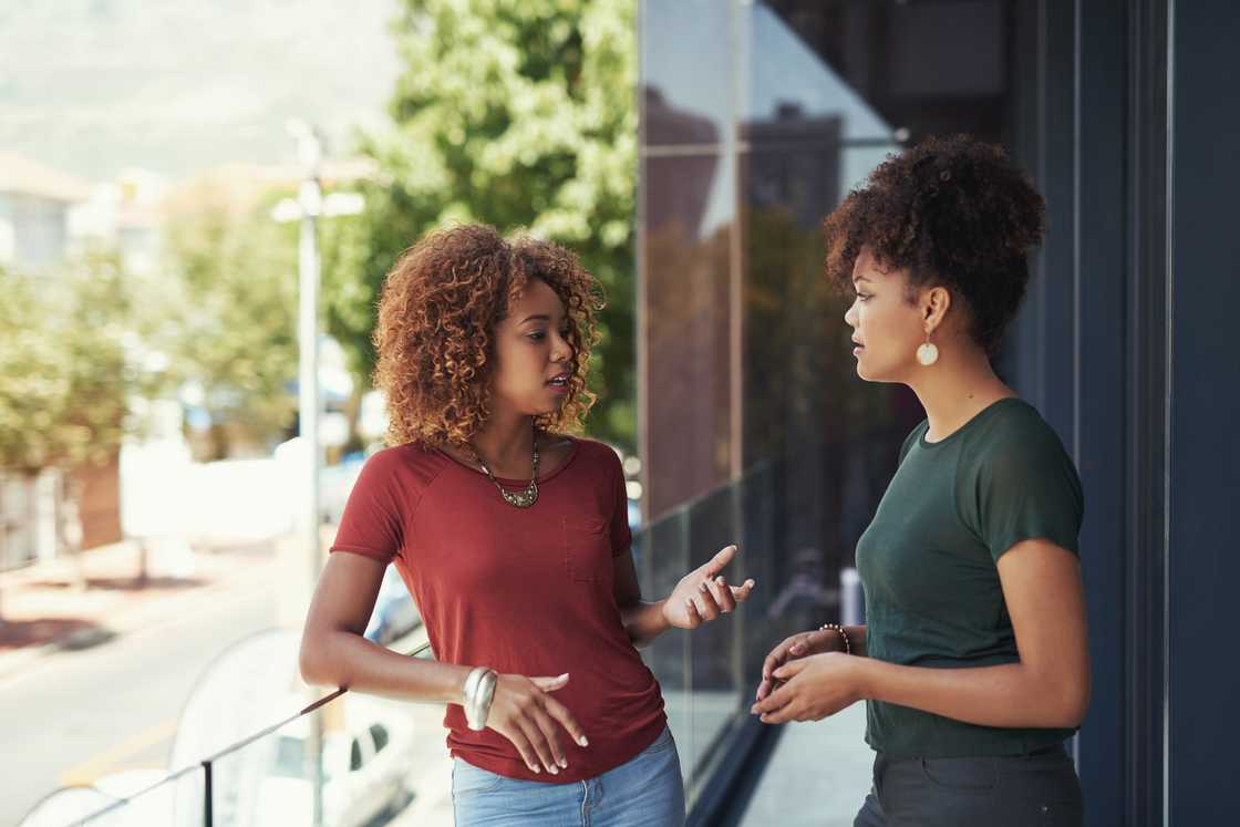 Two women chatting outside on a balcony