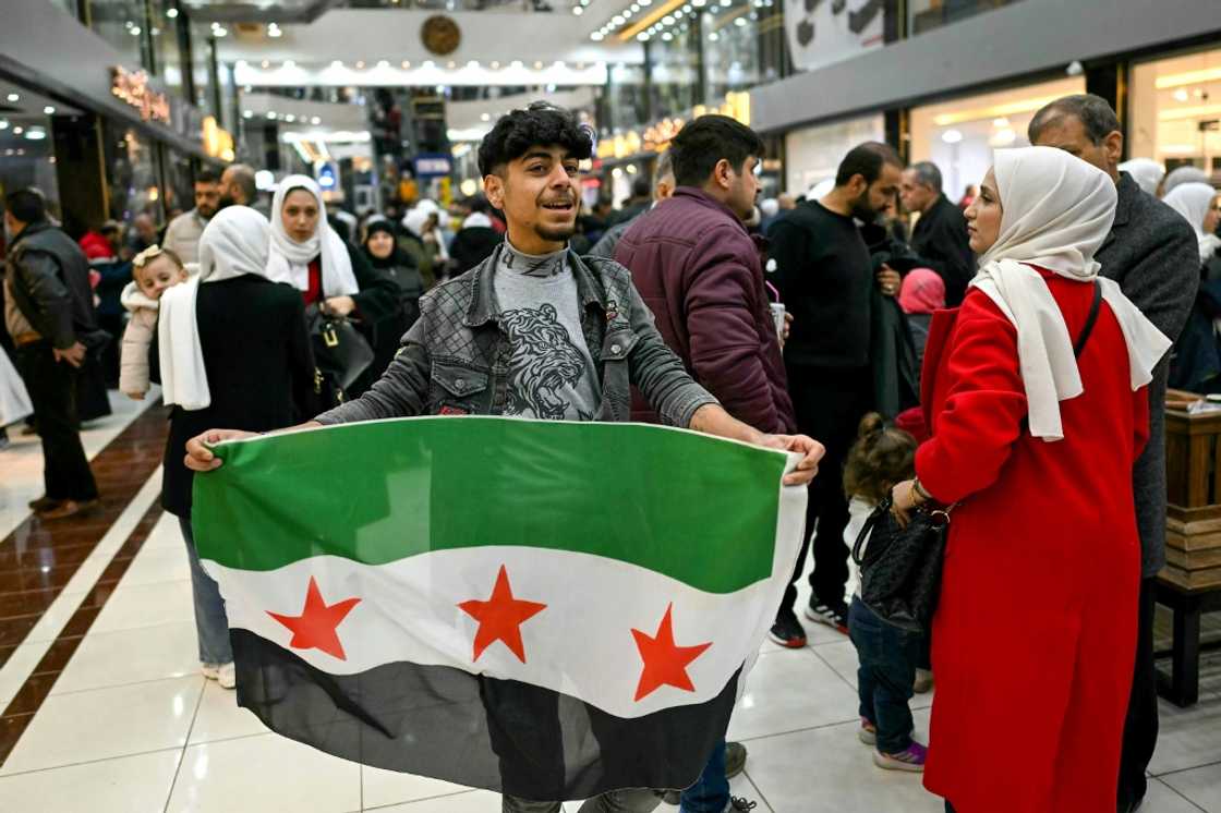 A young man holds a Syrian independence flag in a shopping mall near Sarmada, in the northern province of Idlib A young man holds a Syrian independence flag in a shopping mall near Sarmada, in the northern province of Idlib