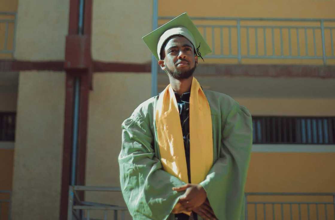 A young man wearing green and yellow graduation gown A young man wearing green and yellow graduation gown