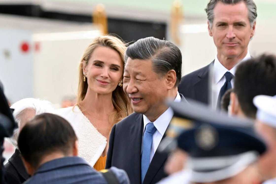 California Governor Gavin Newsom (R) and his partner Jennifer Siebel Newsom (L) look on as Chinese President Xi Jinping (C) arrives at San Francisco International airport