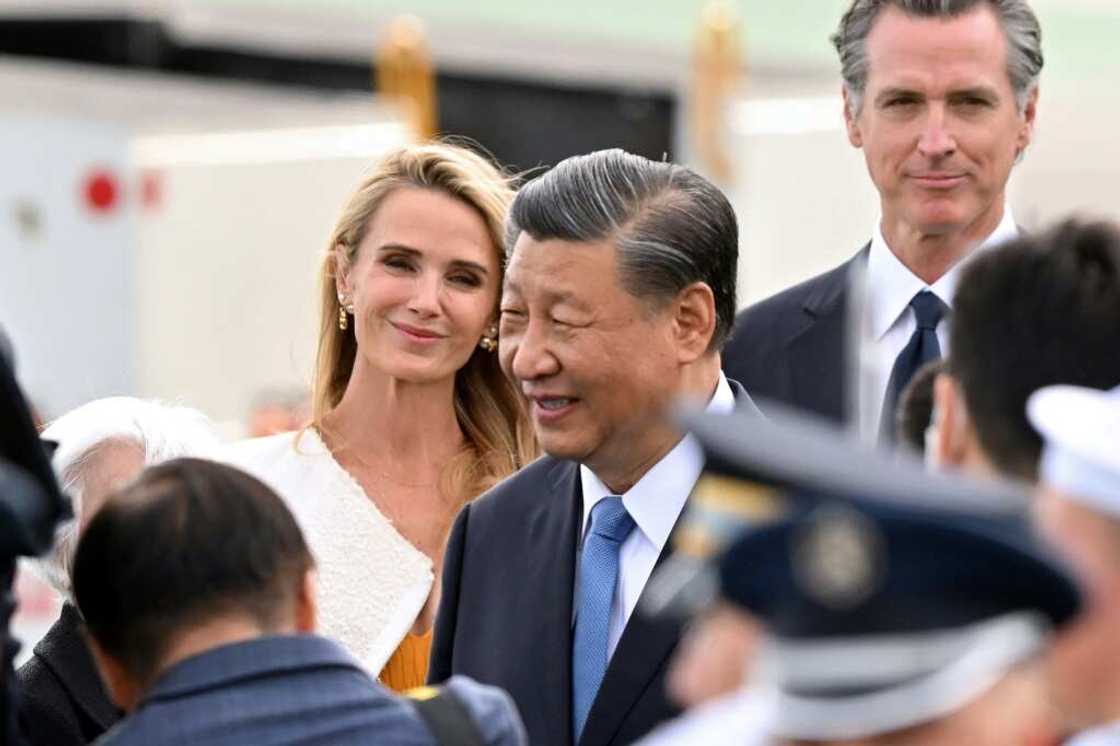 California Governor Gavin Newsom (R) and his partner Jennifer Siebel Newsom (L) look on as Chinese President Xi Jinping (C) arrives at San Francisco International airport California Governor Gavin Newsom (R) and his partner Jennifer Siebel Newsom (L) look on as Chinese President Xi Jinping (C) arrives at San Francisco International airport