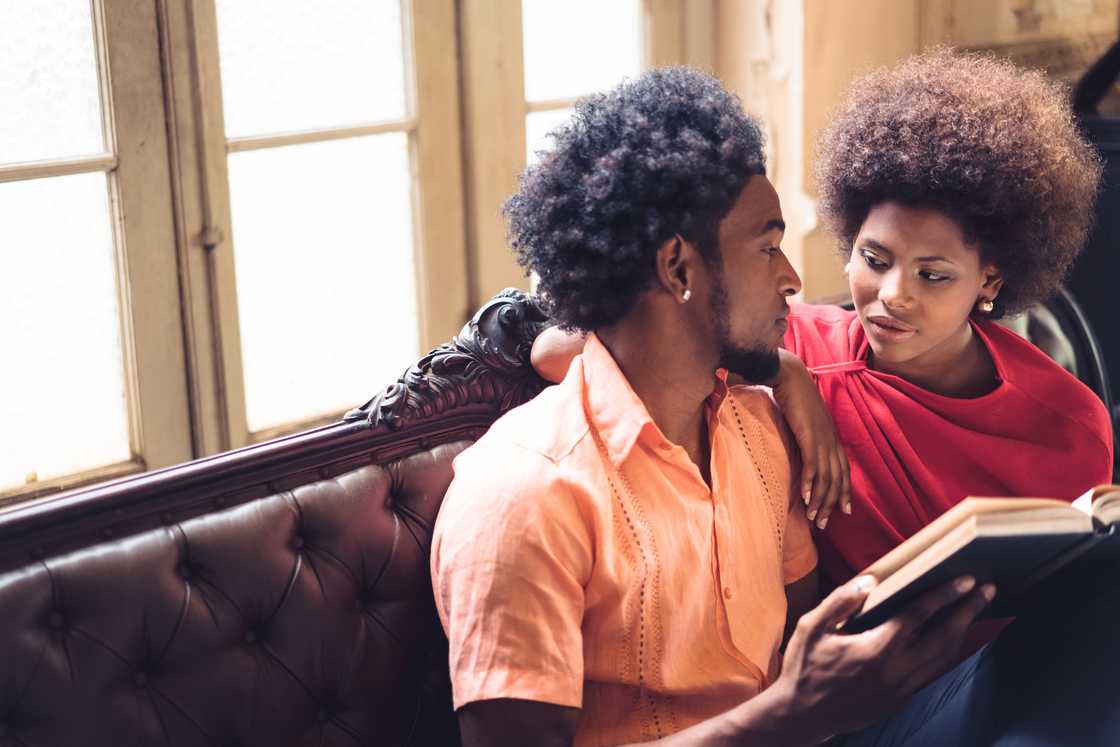 A couple reading quietly in their living room.