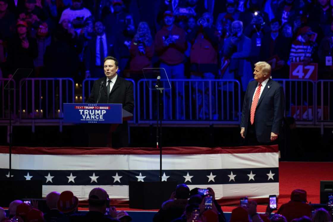 Elon Musk speaks at a MAGA victory rally next to Donald Trump at Capital One Arena on the eve of Inauguration Day