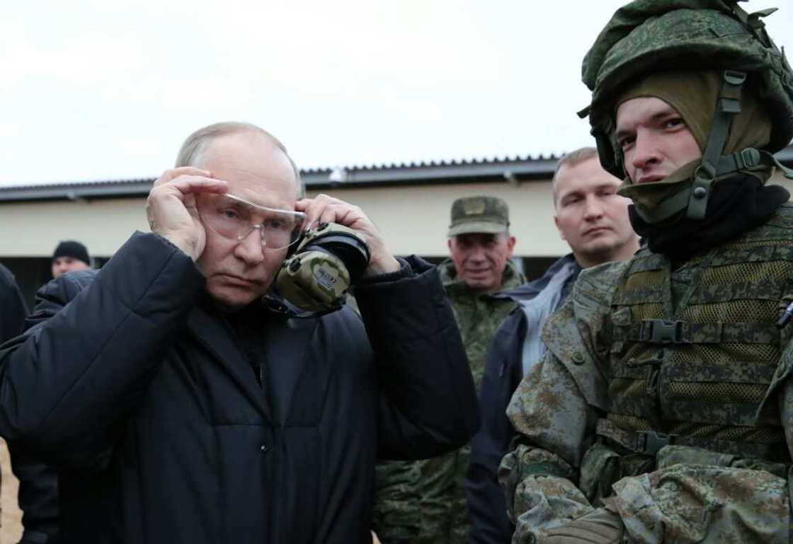 Russian President Vladimir Putin (L) meets soldiers during a visit at a military training centre of the Western Military District for mobilised reservists, outside the town of Ryazan on October 20, 2022. Russian President Vladimir Putin (L) meets soldiers during a visit at a military training centre of the Western Military District for mobilised reservists, outside the town of Ryazan on October 20, 2022.