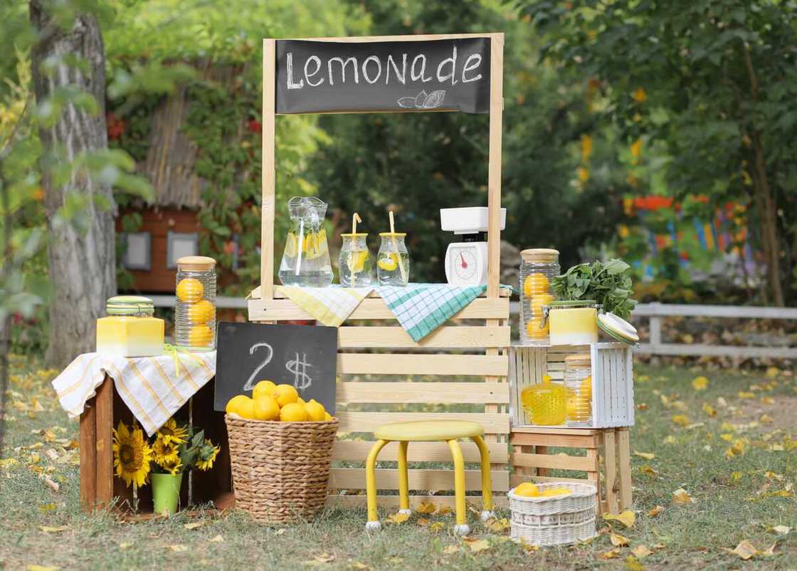 A stand for the sale of lemonade in a green park A stand for the sale of lemonade in a green park
