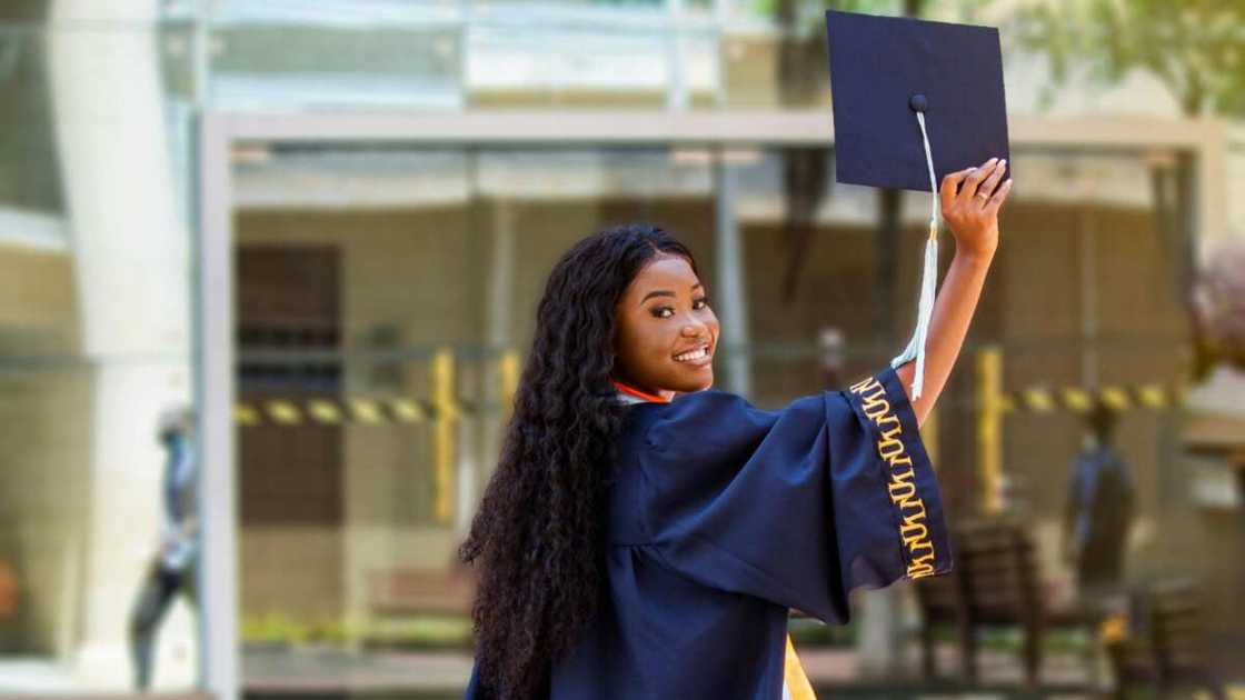 A woman in a blue graduation gown and hat