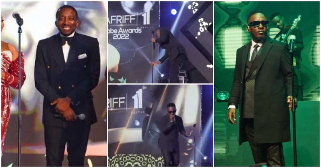 Comedian Bovi adjusts microphone to rapper MI's height at event. Comedian Bovi adjusts microphone to rapper MI's height at event.