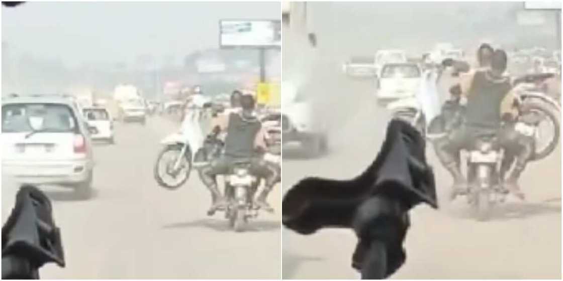 A man on bike carry motorcycle on his lap