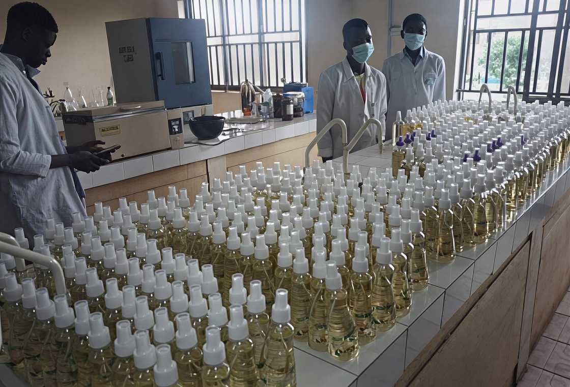 Students and staff stand infront of a display of handsanitizers