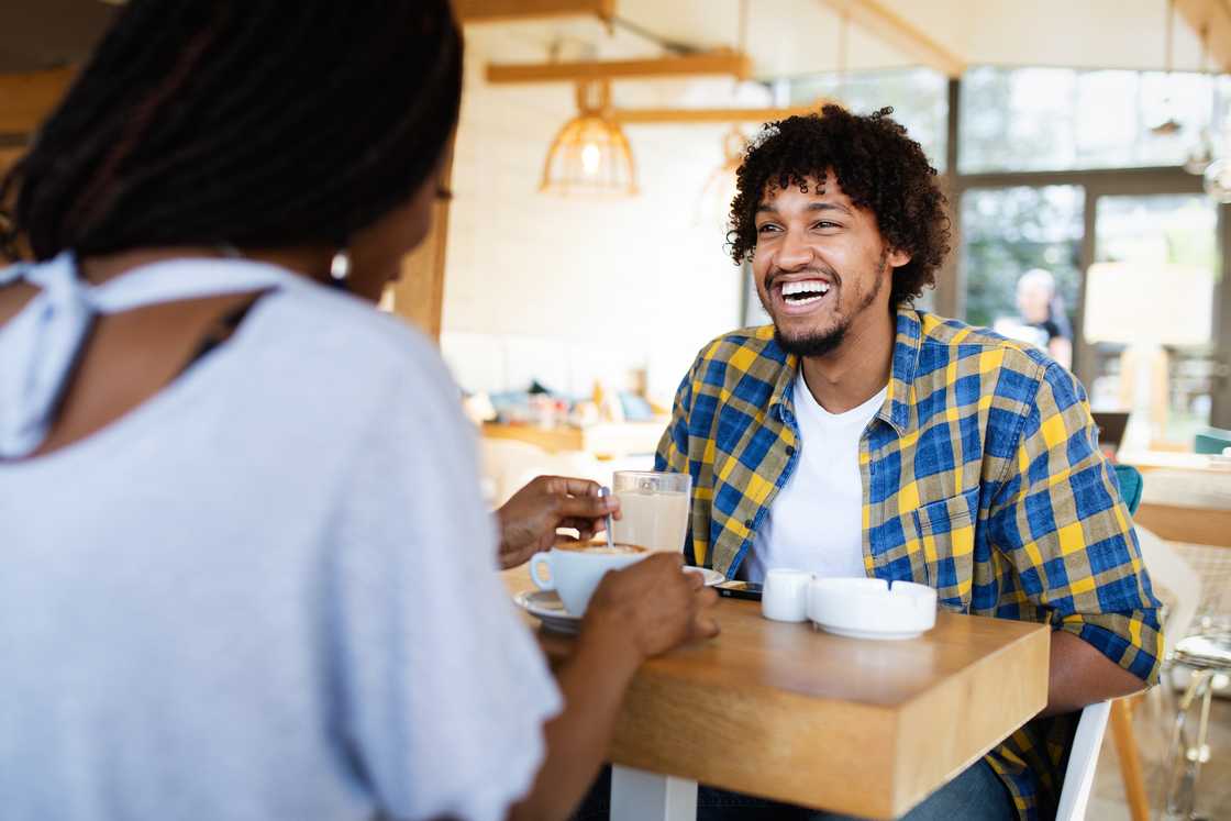 A man and a lady at a cafe chatting A man and a lady at a cafe chatting