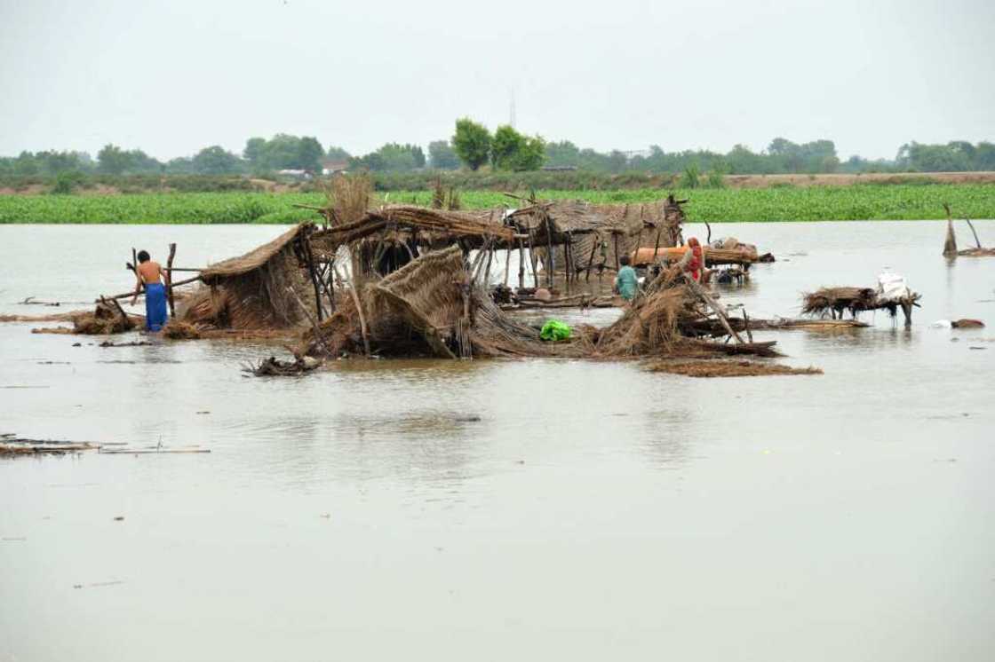 Villagers search for their belongings after their huts were destroyed by flood waters in Jaffarabad, Balochistan province