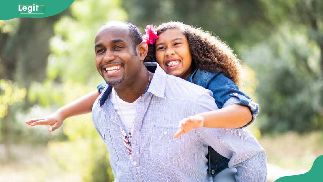An middle-aged man carrying a child on the back An middle-aged man carrying a child on the back