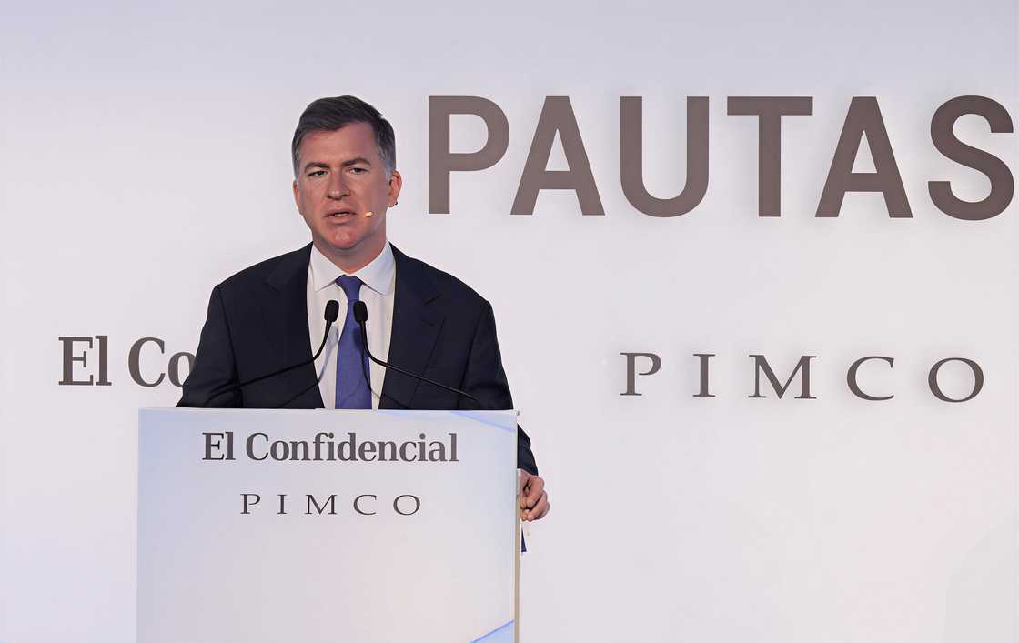 Christian Stracke speaks on a podium.