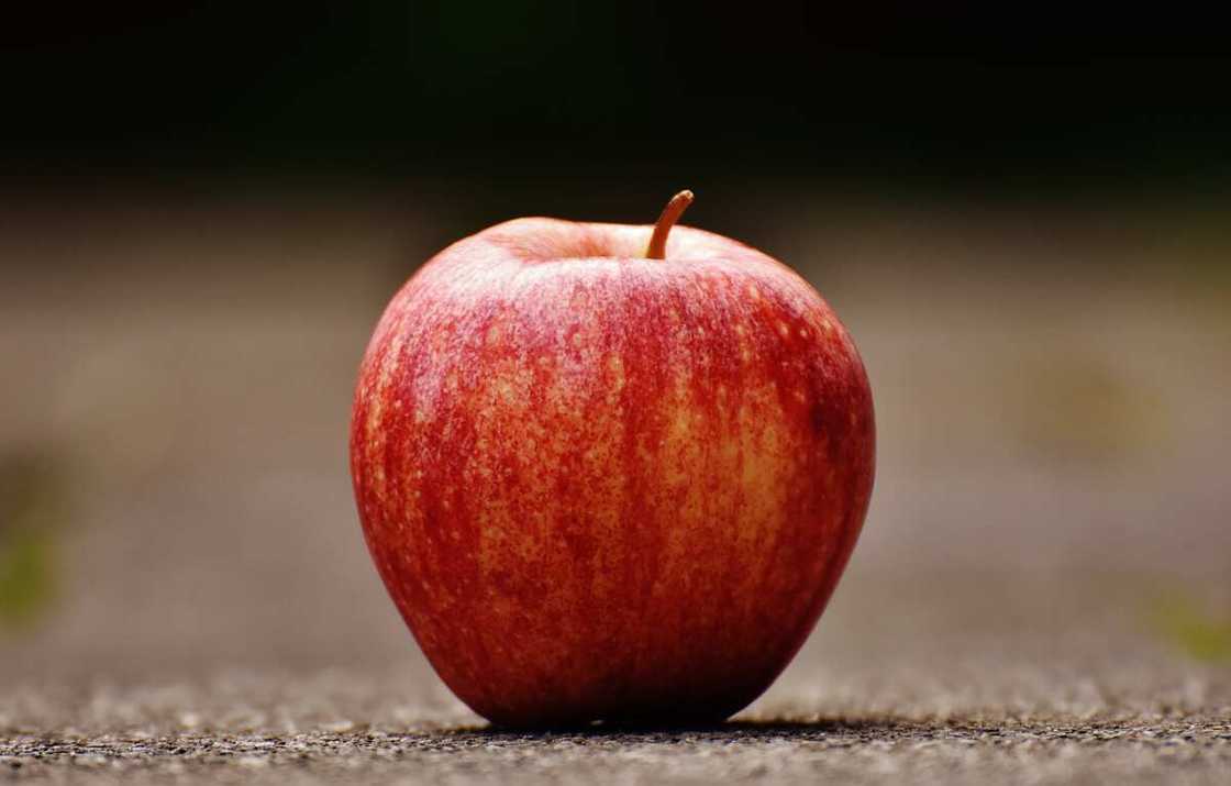 An apple on a grey surface An apple on a grey surface