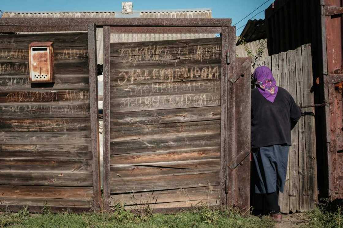 Vera Schetynkyna enters her house in the recently retaken town of Yampil, near Lyman, in the Donetsk region