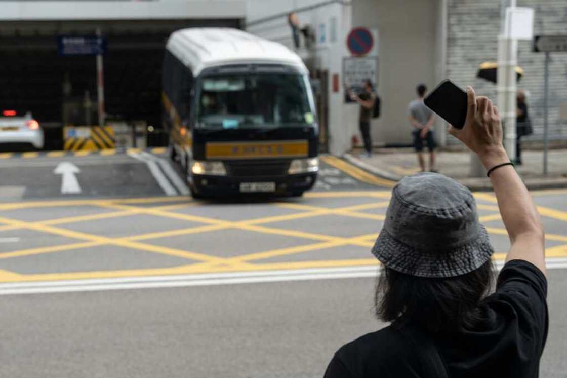 A supporter of the pro-democracy unionists waves at a prison van believed to be transporting the group