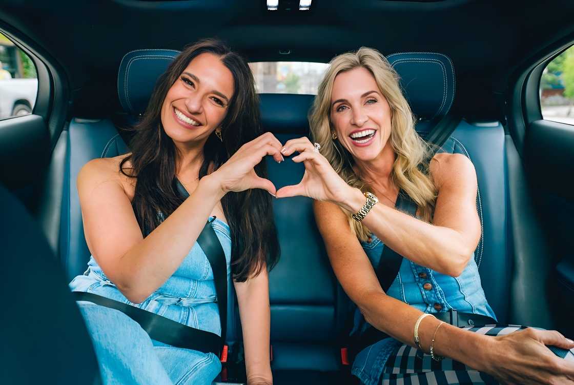 Lise and Nicci make a 'heart' gesture with their hands