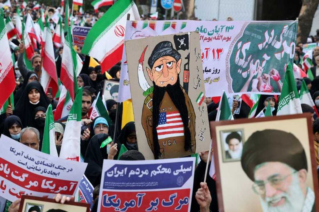 Iranians wave their country's national flag at a rally outside the former US embassy in Tehran Iranians wave their country's national flag at a rally outside the former US embassy in Tehran
