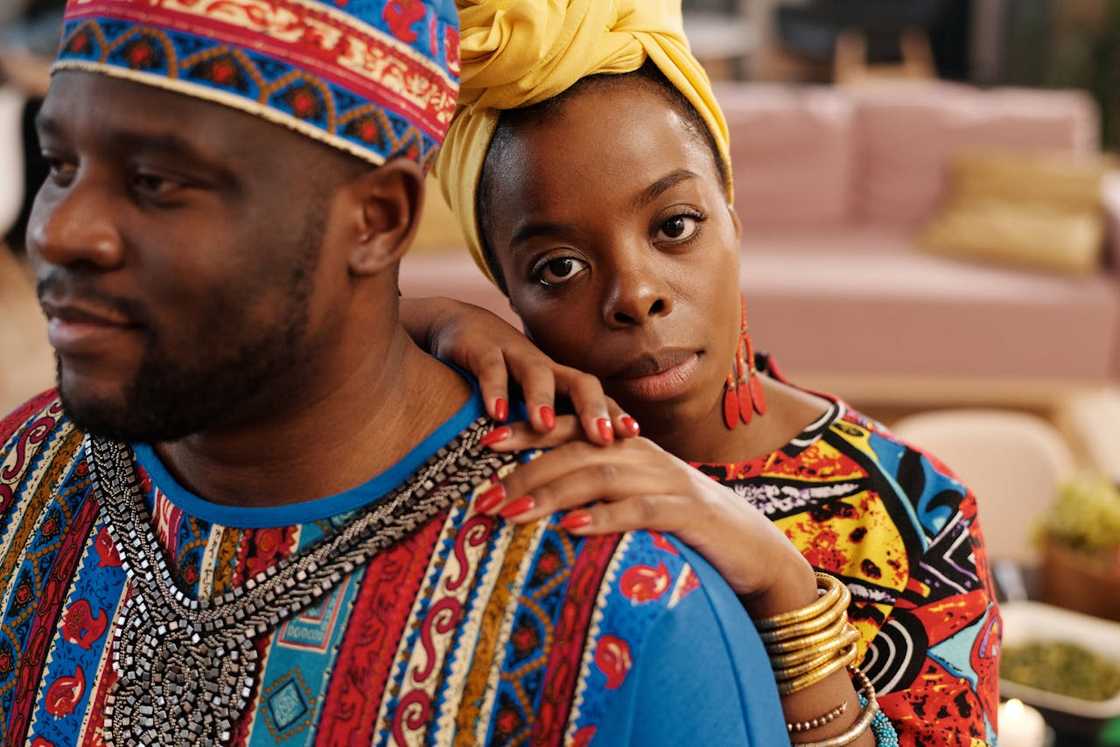 Woman resting her chin on a man’s shoulder, looking serious.