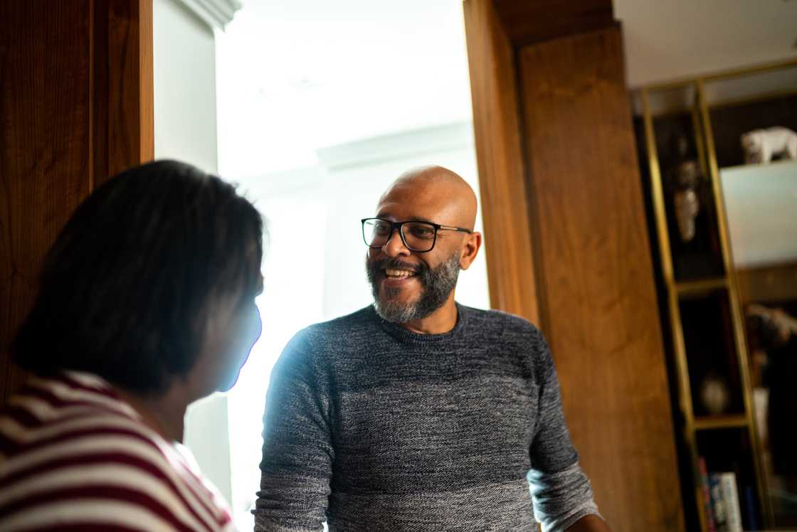 A mature man talking to a woman indoors