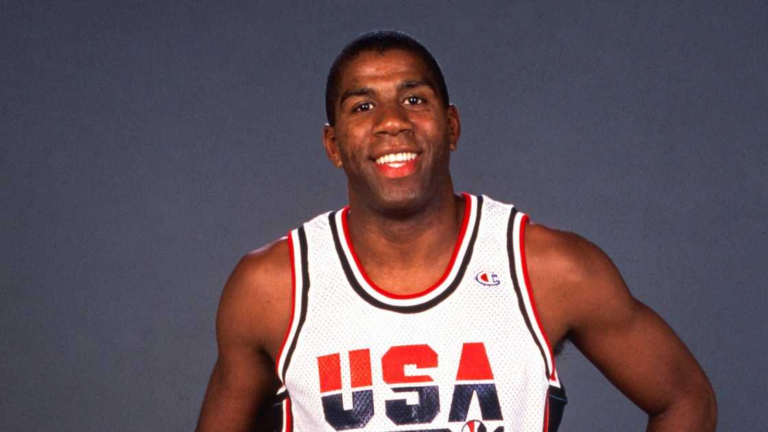 Magic Johnson poses standing, in the USA Senior Men's basketball team kit.