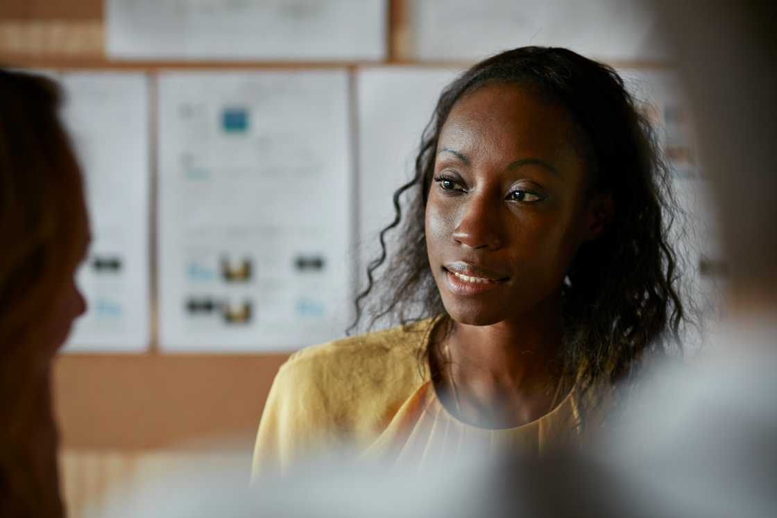 A woman is listening to a co-worker