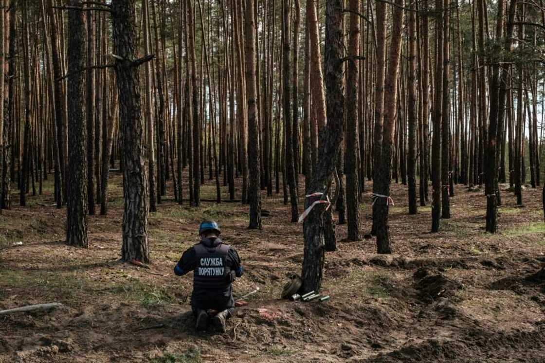 A Ukrainian national police emergency demining team's officer prepares to detonate collected anti-tank mines and explosives near the recently retaken town of Lyman in Donetsk region