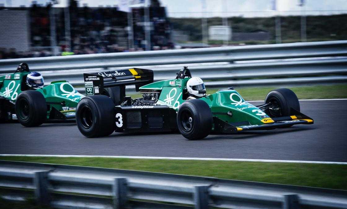 Timelapse photography of green racing vehicle on lane Timelapse photography of green racing vehicle on lane