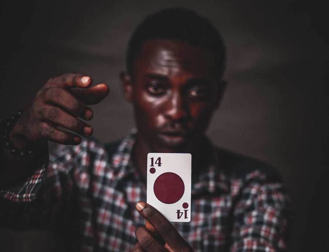 A man holding a single card + single-player card games A man holding a single card + single-player card games