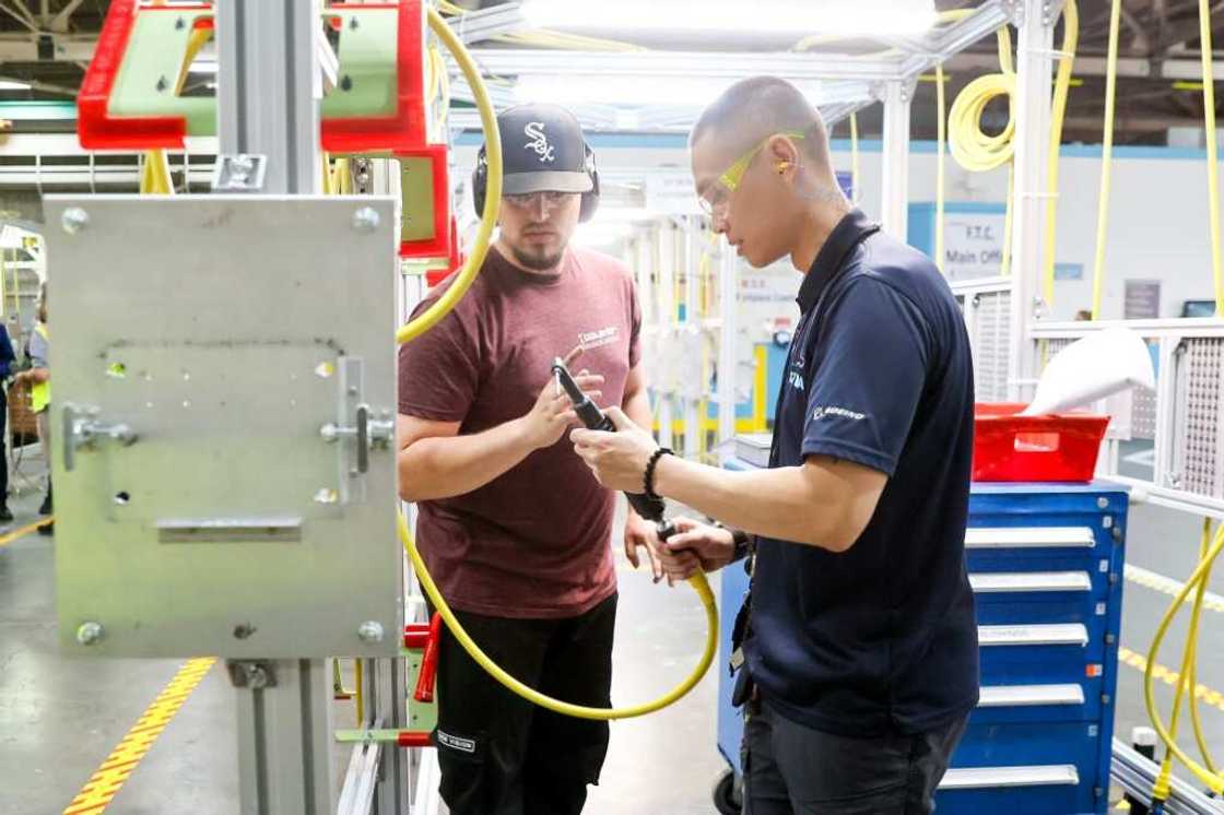 Instructor Andy Tran (R) works with Dmitriy Rudenko on a 90-degree motor at the Boeing Foundational Training Center in Renton, Washington Instructor Andy Tran (R) works with Dmitriy Rudenko on a 90-degree motor at the Boeing Foundational Training Center in Renton, Washington