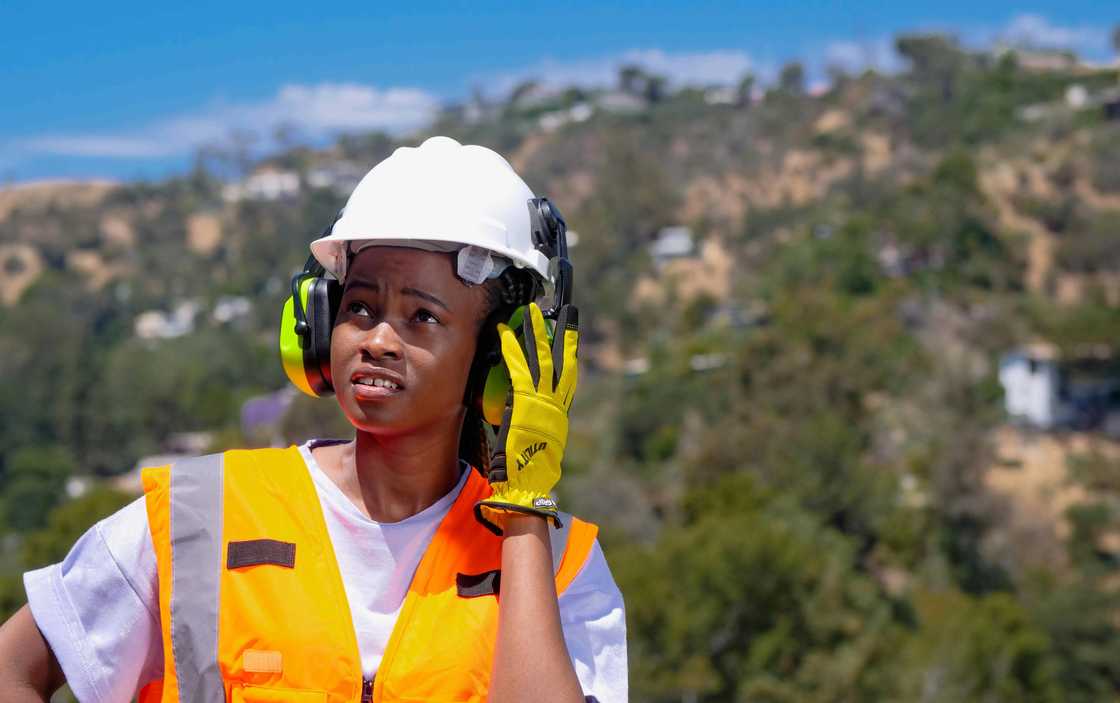 A female engineer with headset looking up A female engineer with headset looking up