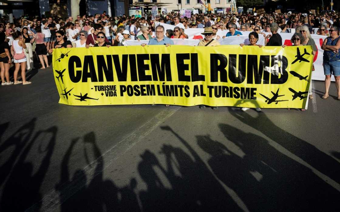 Protesters hold a banner which reads 'Let's change course'