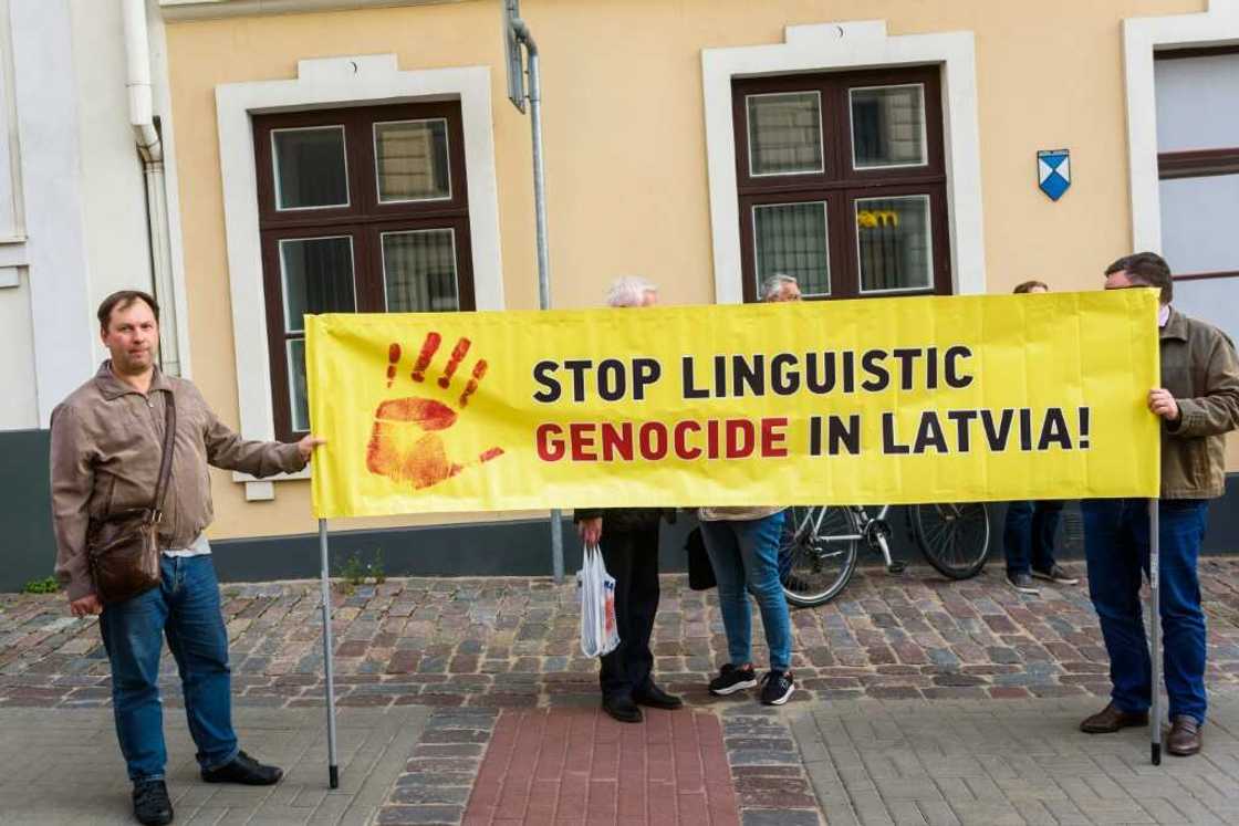 People hold a banner to protest language reforms which Latvia's Russian-speaking miniroty say are increasing their cultural marginalisation People hold a banner to protest language reforms which Latvia's Russian-speaking miniroty say are increasing their cultural marginalisation