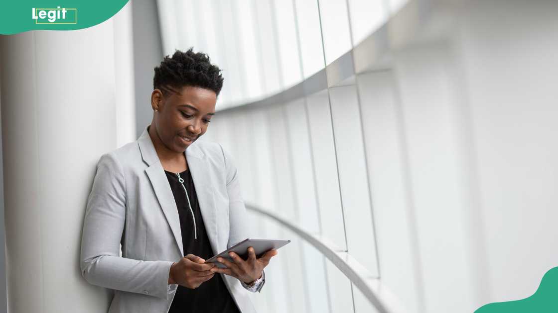 A woman standing while holding a tablet