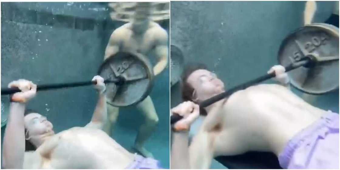 Young man displays weightlifting skills under water Young man displays weightlifting skills under water