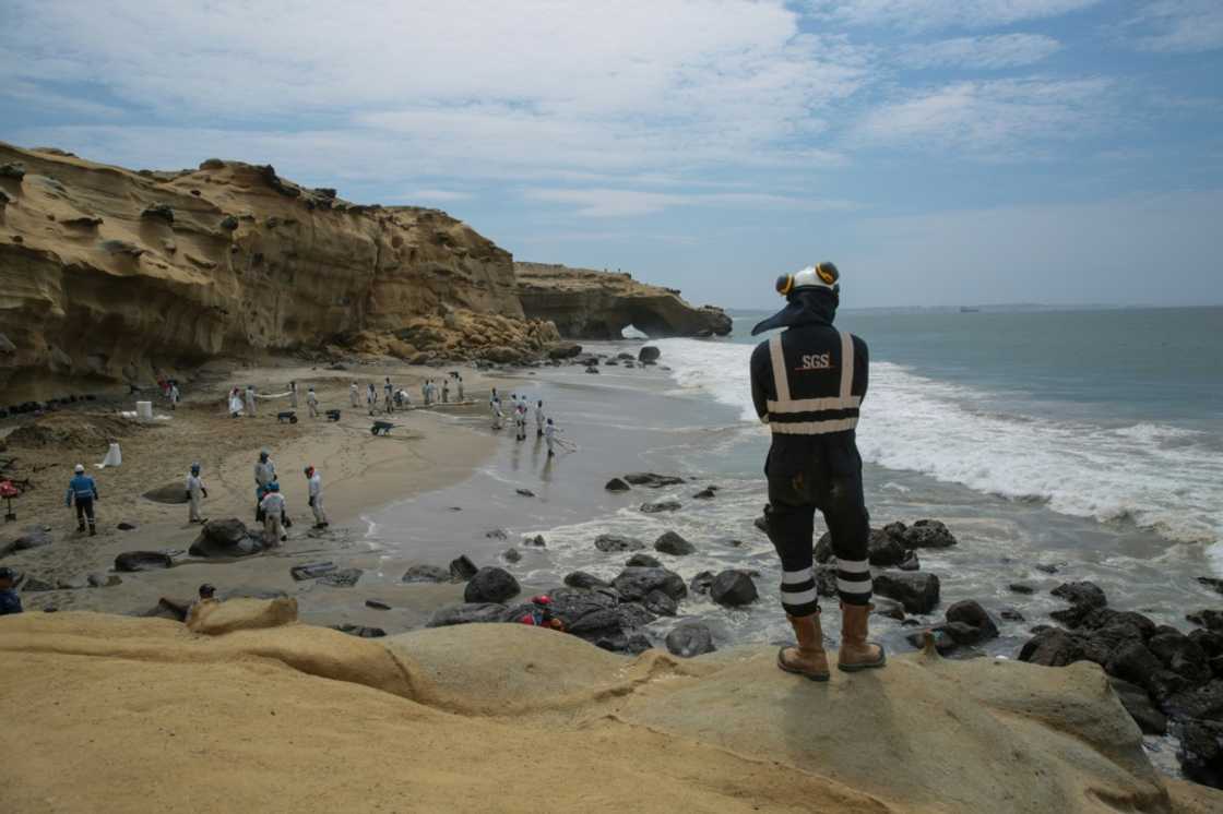 A picture released by the NGO Coast 2 Coast Movement shows workers cleaning up Peru's Las Capullanas beach after an oil spill