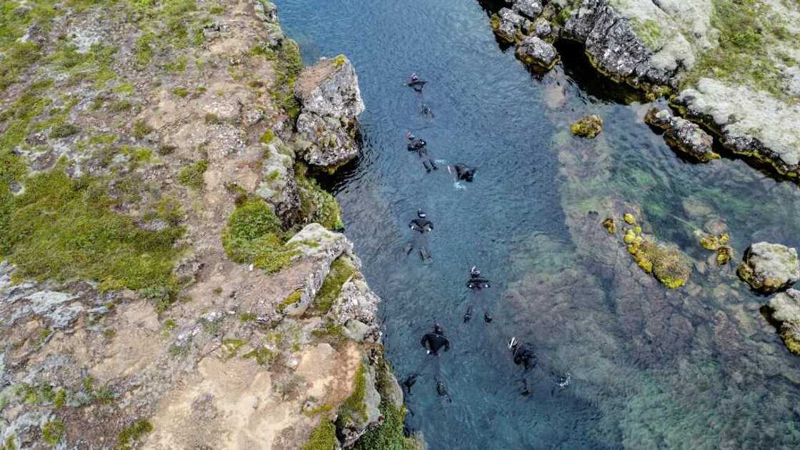 Taking a dip in Silfra requires a lot of preparation: dry suit, diving gloves, swimming hat, mask, snorkel, and fins Taking a dip in Silfra requires a lot of preparation: dry suit, diving gloves, swimming hat, mask, snorkel, and fins