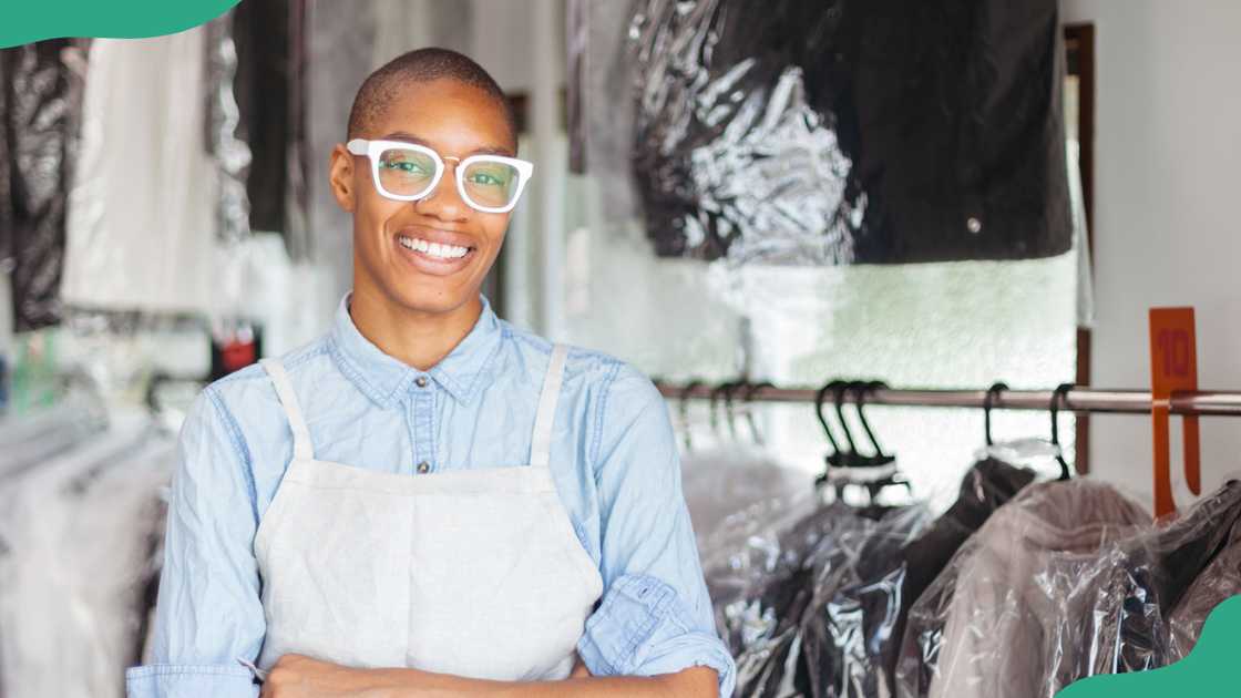 A young person smiles in a dry cleaning business