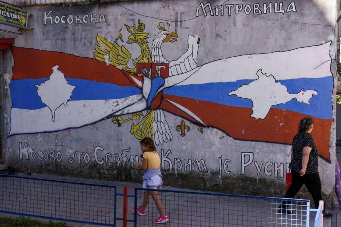 A child walks by a mural reading 'Kosovo is Serbia -- Crimea is Russia' in a Serb part of Mitrovica, Kosovo A child walks by a mural reading 'Kosovo is Serbia -- Crimea is Russia' in a Serb part of Mitrovica, Kosovo
