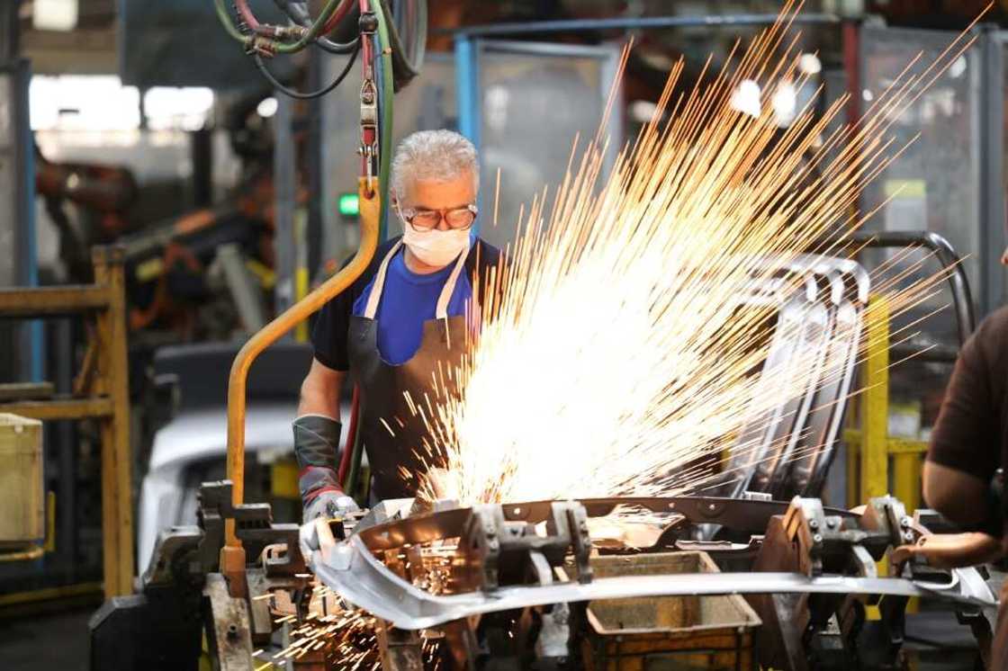 Technicians work on Peugeot 207 and 206 car production lines at the Iran Khodro plant on August 14, 2022 Technicians work on Peugeot 207 and 206 car production lines at the Iran Khodro plant on August 14, 2022