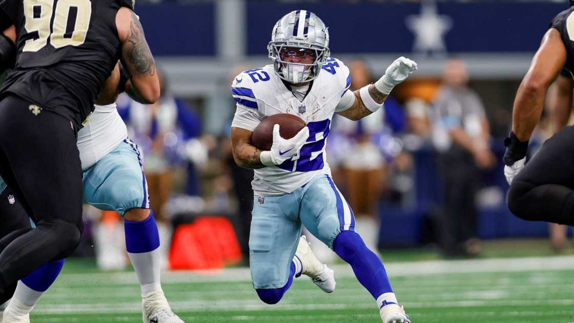 Deuce Vaughn of the Dallas Cowboys runs through the scrimmage line.