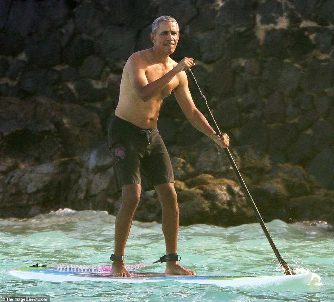 Barack Obama goes paddleboarding shirtless in Hawaii in $84 shark deterrent ankle band