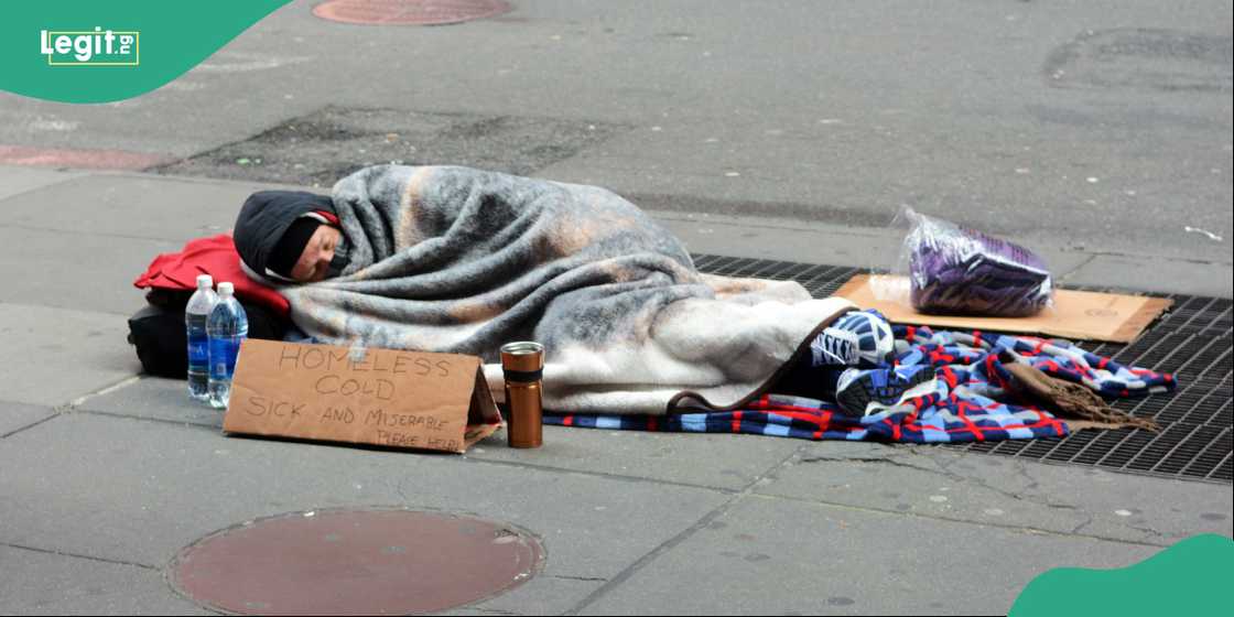 Homeless, cold, sick, and miserable man, sleeping on a sidewalk in Manhattan