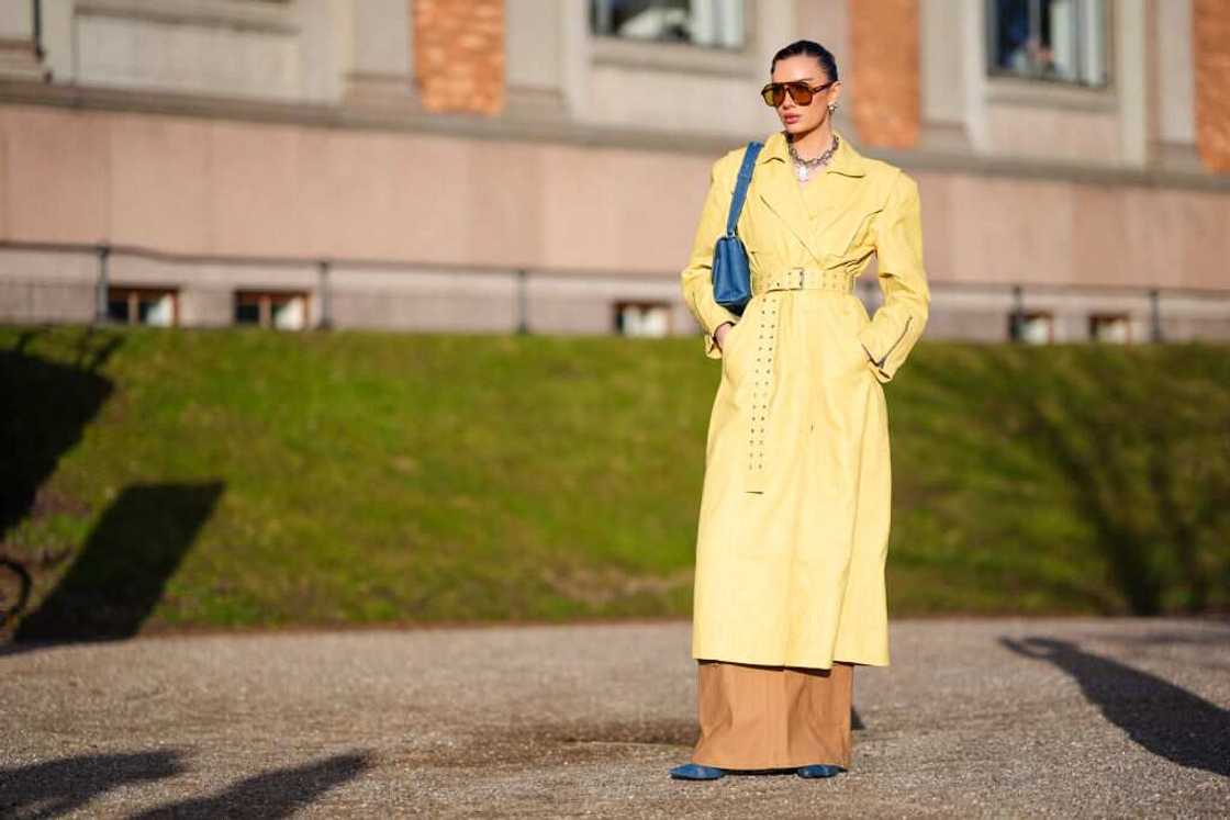 A lady donning a long yellow coat.