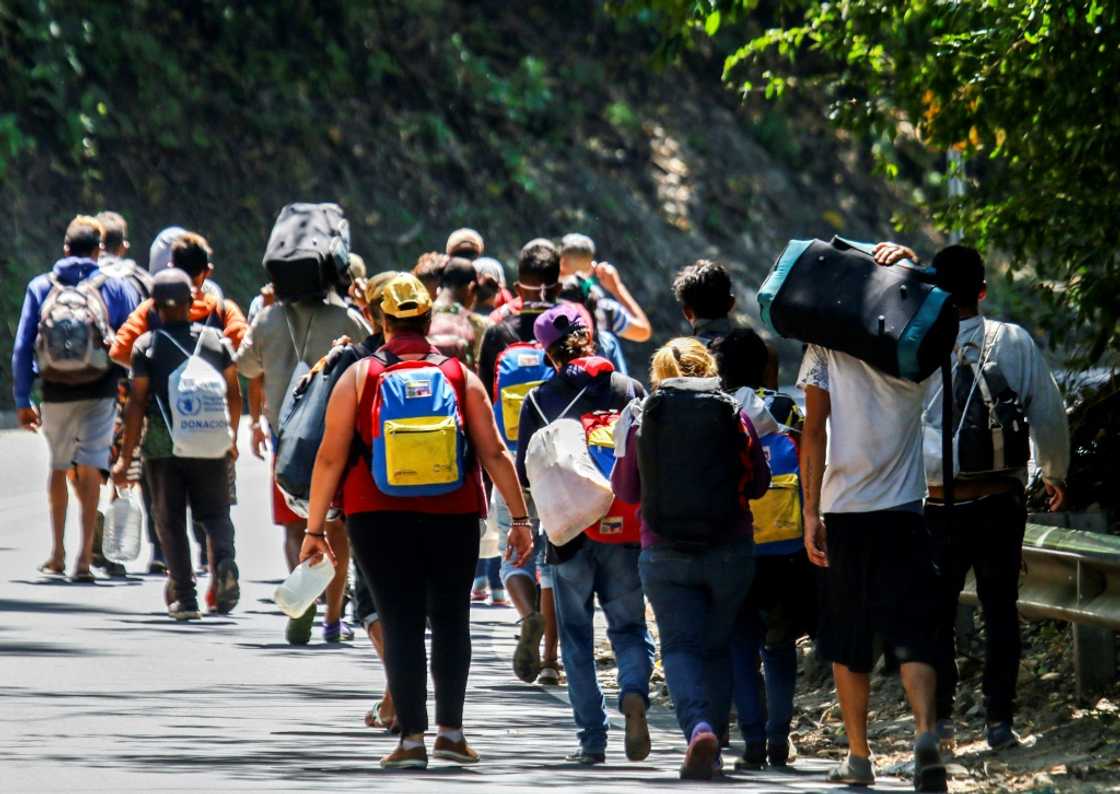 Venezuelan migrants walk along a road in Colombia in 2021