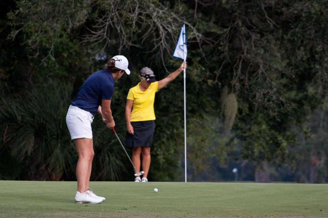 A man wearing white shorts playing golf A man wearing white shorts playing golf