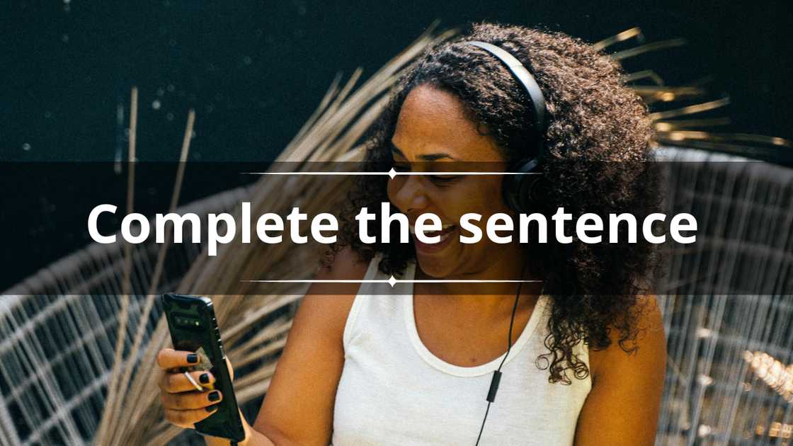 A happy woman in a white tank top laughs while using her phone