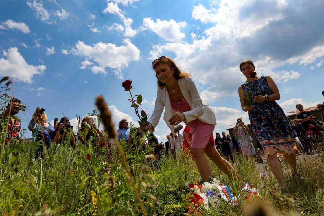 People lay roses on a field in front of the Czech pig farm built on the site of a WWII concentration camp for the Roma People lay roses on a field in front of the Czech pig farm built on the site of a WWII concentration camp for the Roma