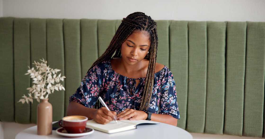 A lady is journaling at a cafe