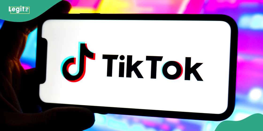 A TikTok logo is displayed on the screen of a smartphone